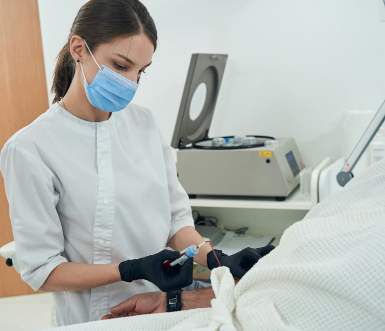 Doctor taking blood sample from patient in clinic