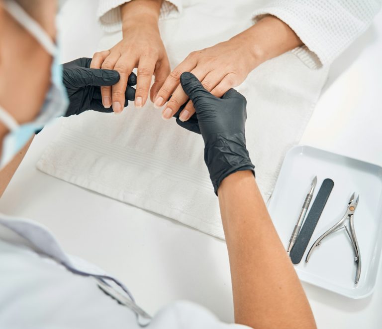 Focused photo on nail master examining fingers