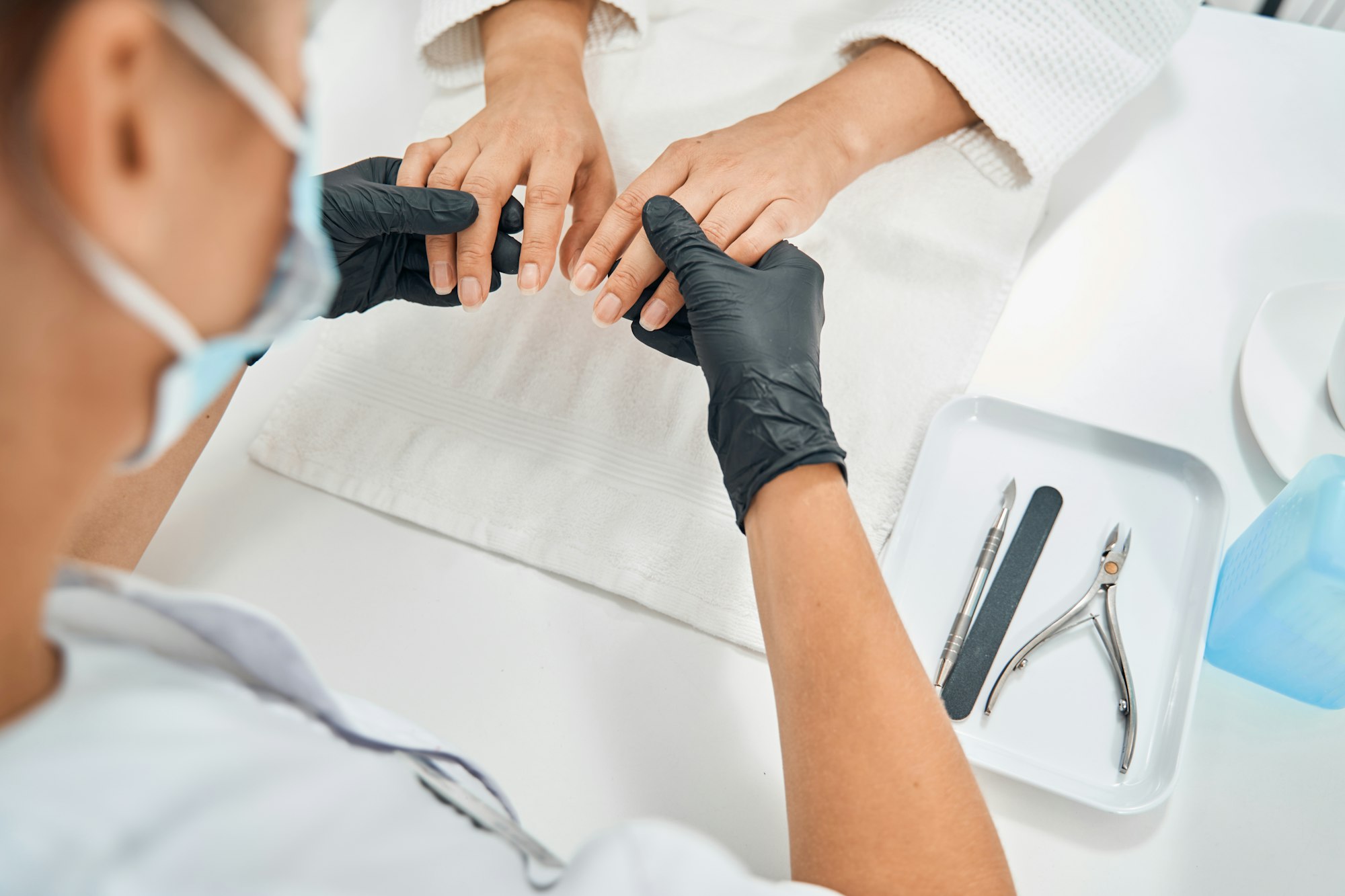 Focused photo on nail master examining fingers