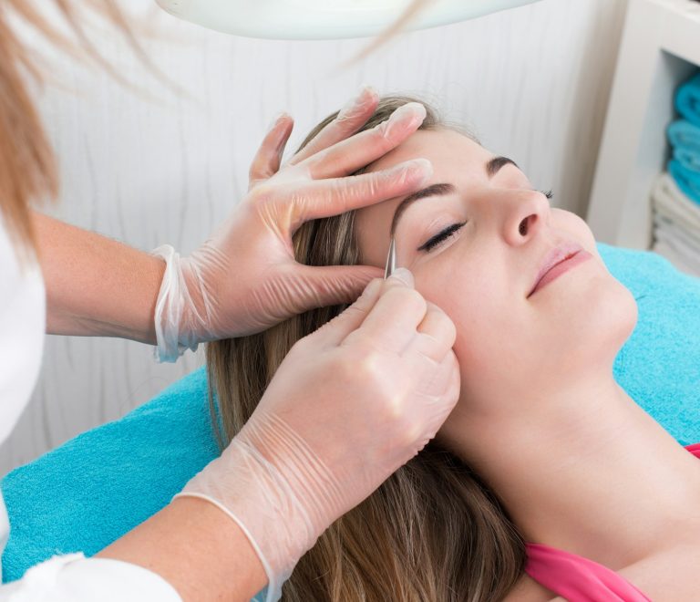 Woman getting tweezing eyebrow