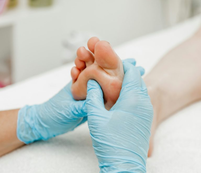 Foot massage in a spa salon, close-up. masseur with gloves massages feet